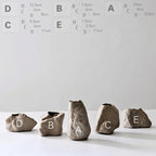 Set of stone vases with size labels on a white background