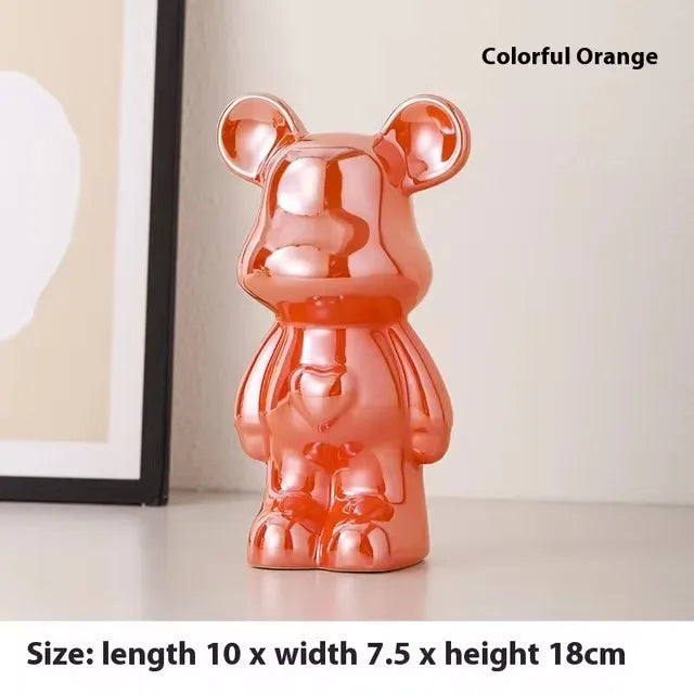 A glossy metallic orange bear-shaped decorative object standing on a tabletop, with text reading 'Colorful Orange' and size information below.