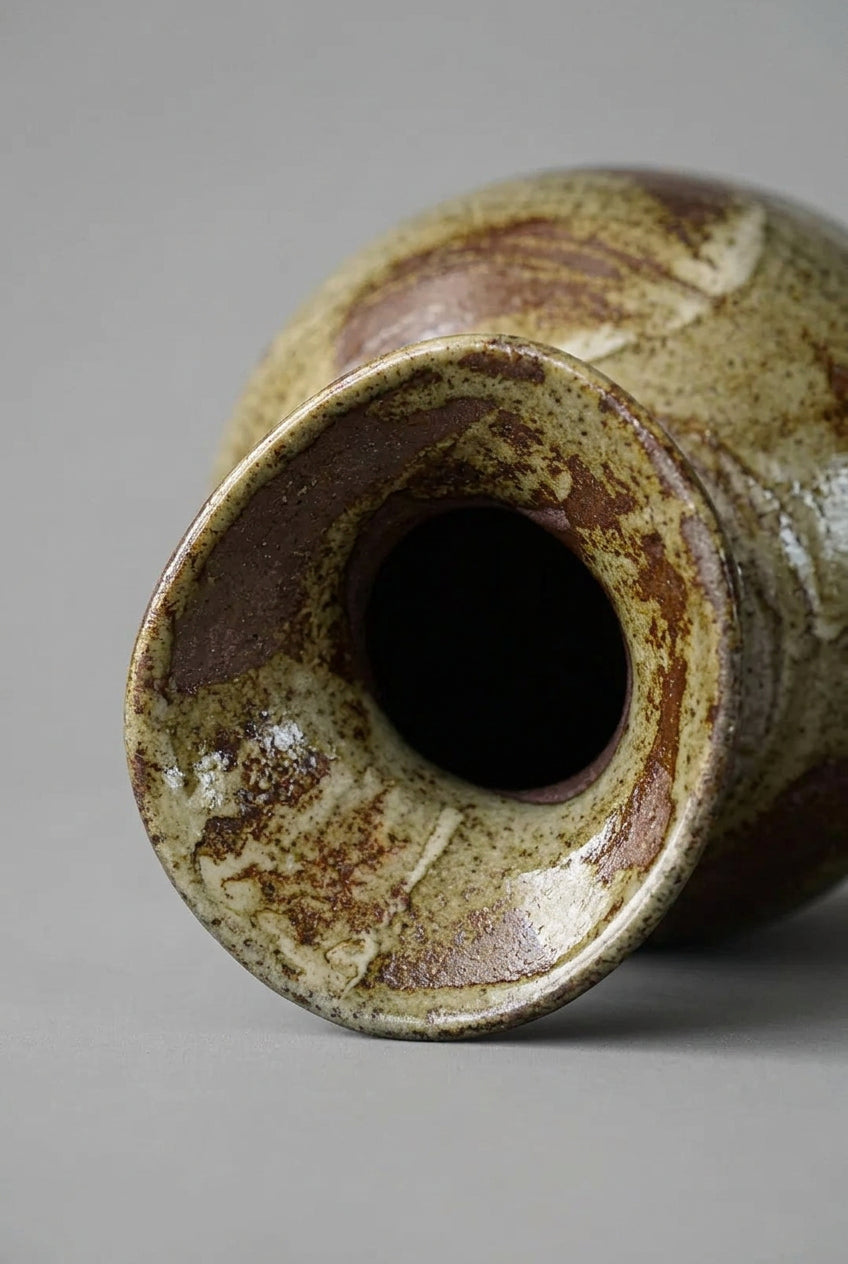 Close-up of a ceramic vase with a textured surface and brownish glaze.