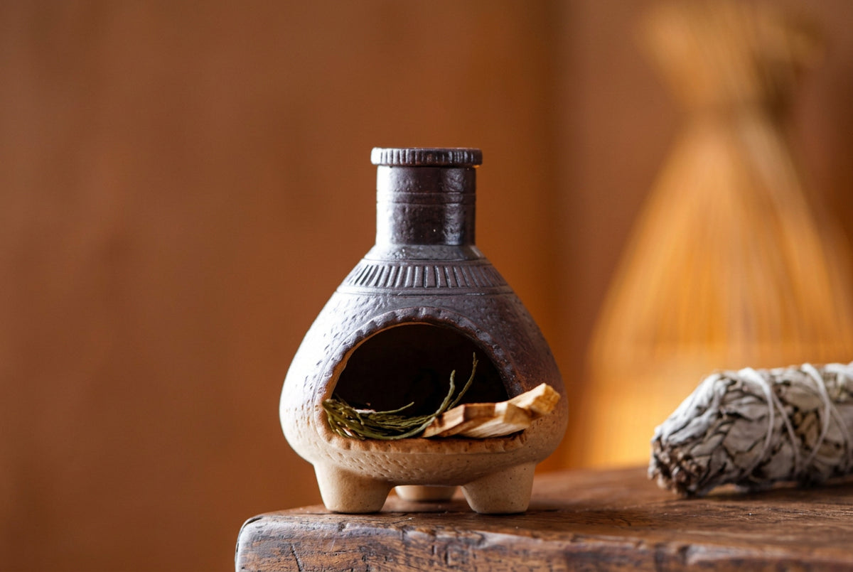 Small ceramic stove with size indication on a wooden surface