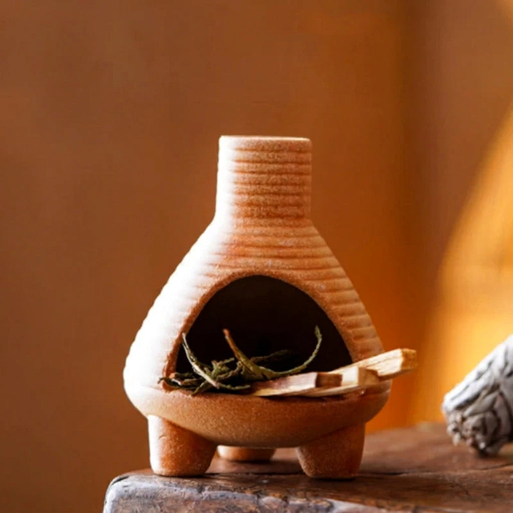 Small terracotta chiminea with size information on a wooden surface.