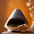 Ceramic birdhouse with natural elements on a wooden surface, size indicated.