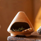 Small terracotta oven with greenery on a wooden surface, size indicated.